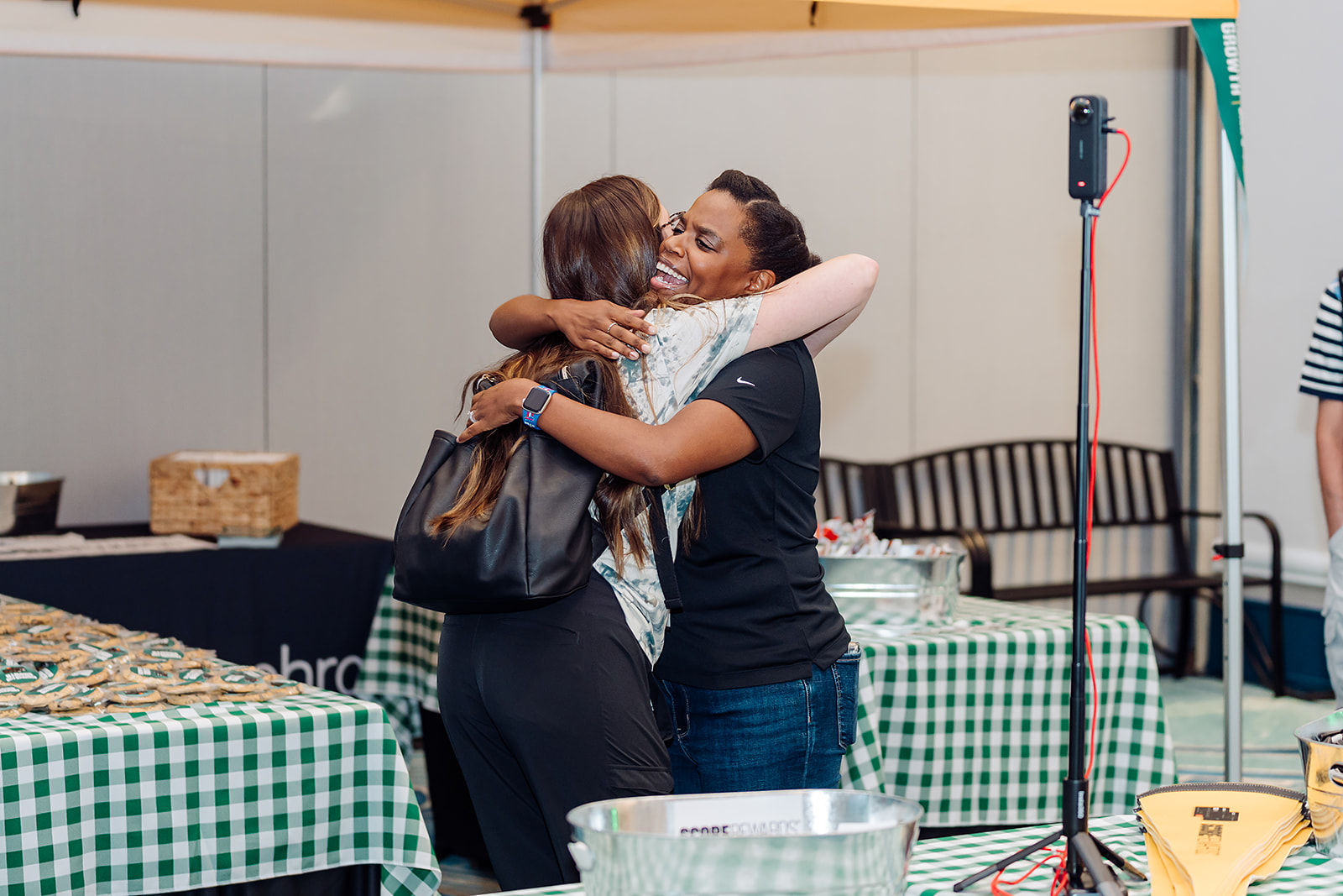 Two conference attendees share a warm candid moment